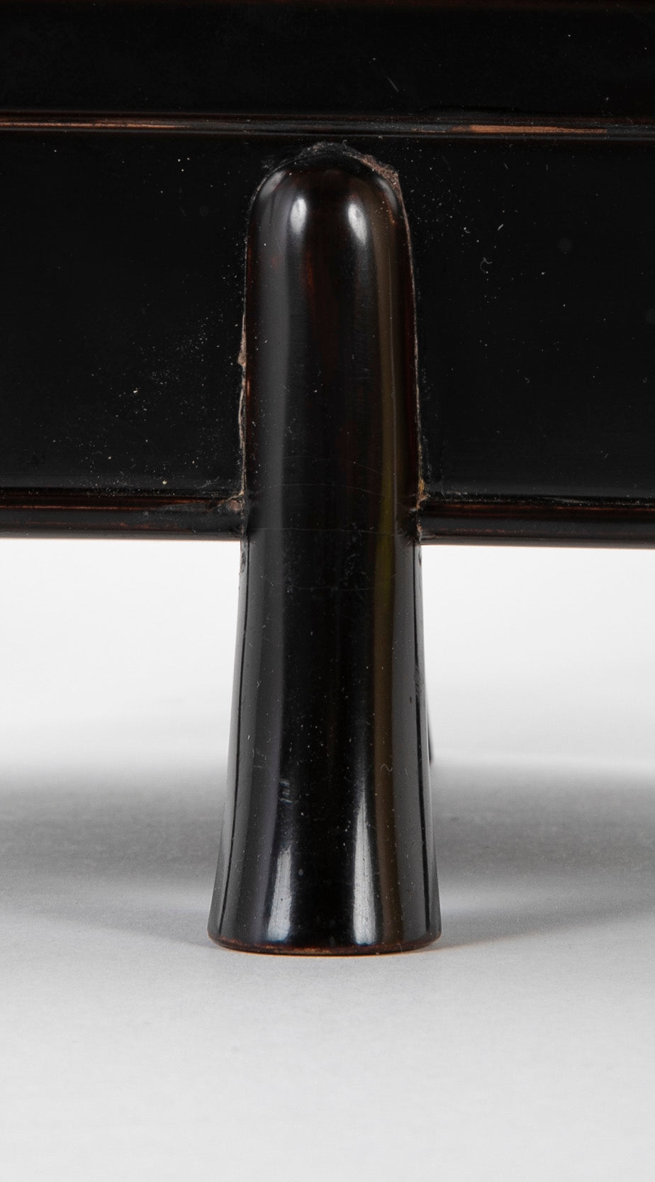 A Japanese Black Lacquer Faceted Covered Box on Four Splayed Feet