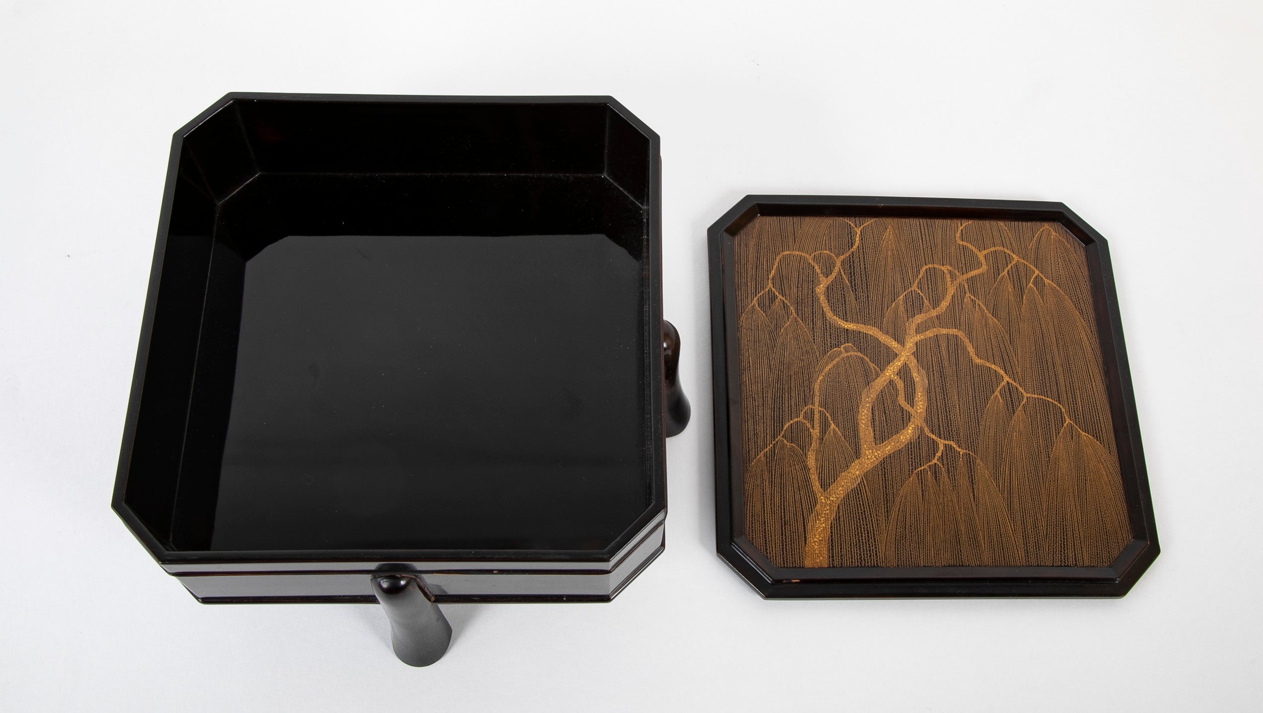 A Japanese Black Lacquer Faceted Covered Box on Four Splayed Feet