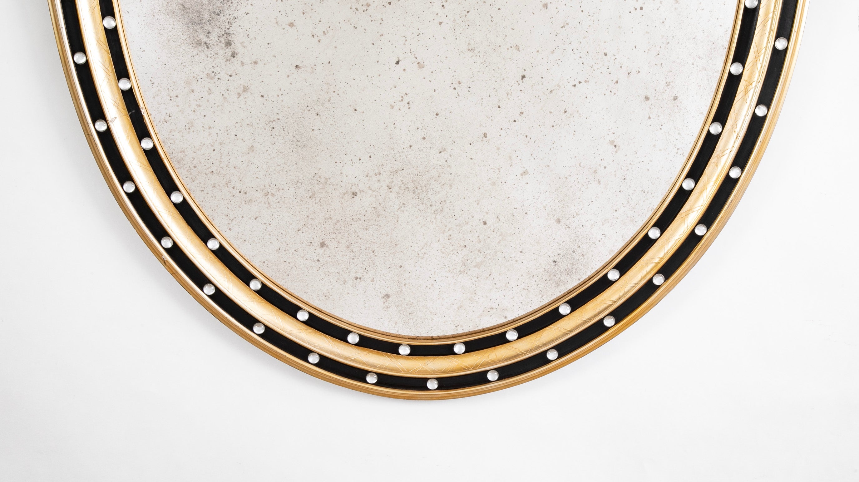 An Irish Ebonized & Parcel Gilt Oval Mirror with Faceted Bead Decoration