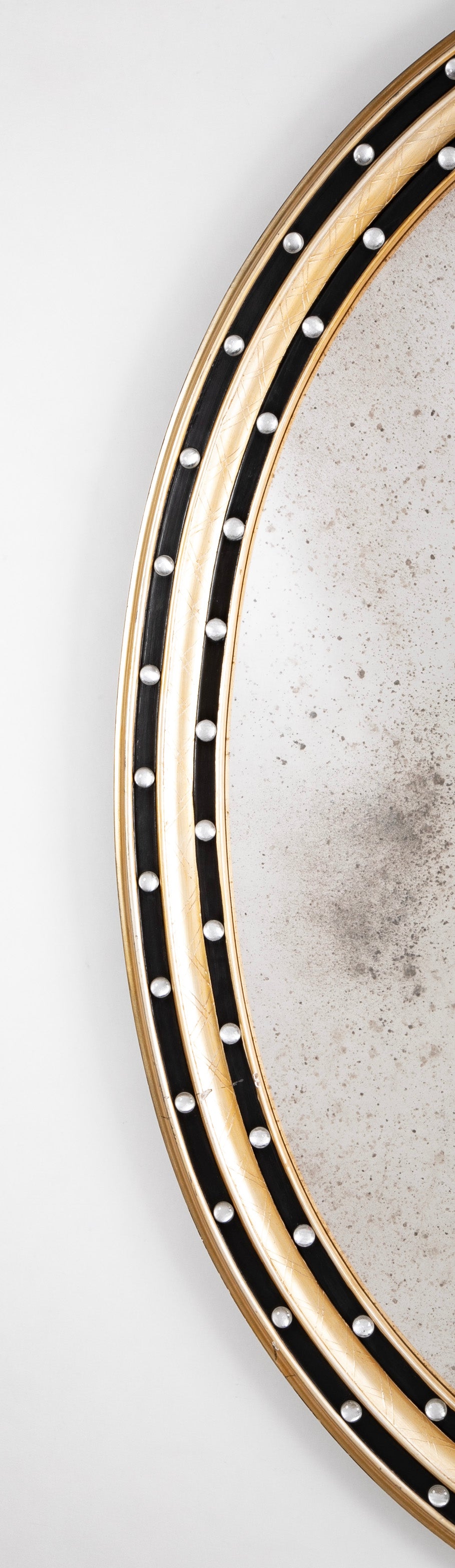 An Irish Ebonized & Parcel Gilt Oval Mirror with Faceted Bead Decoration
