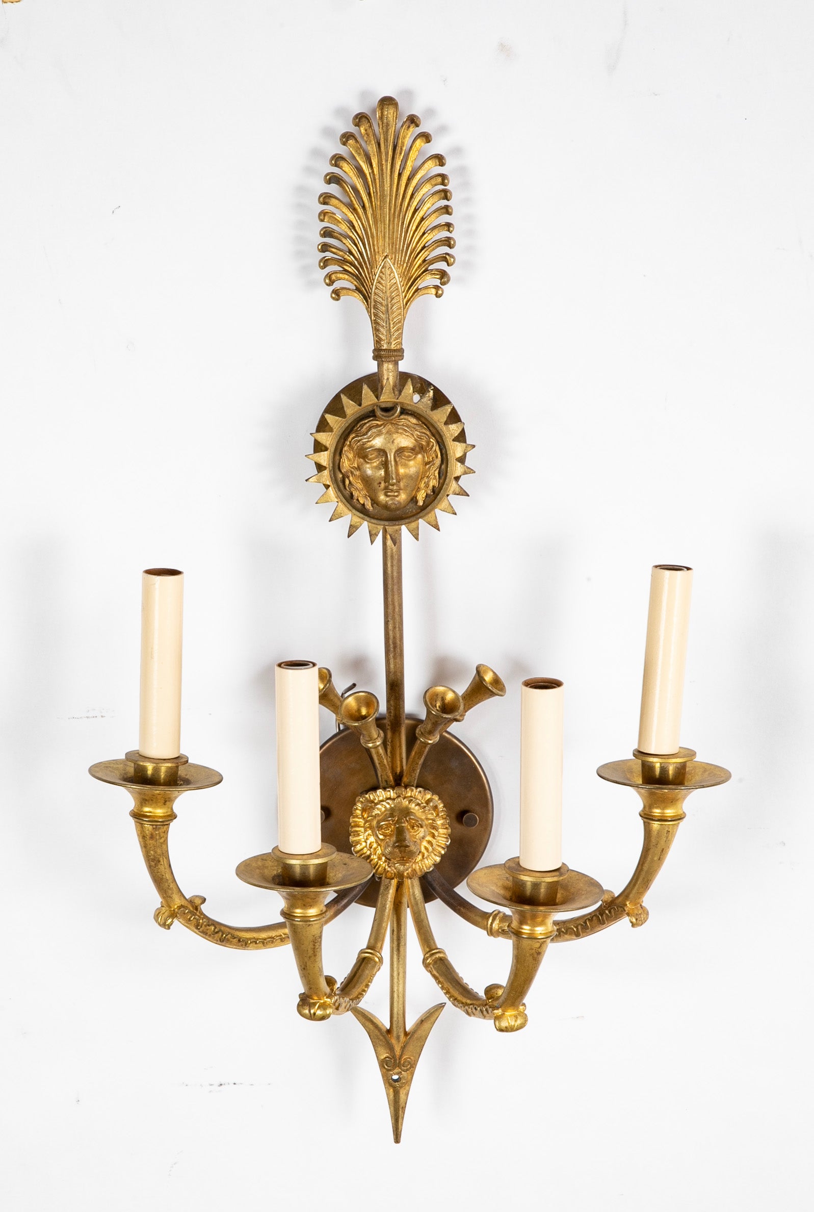 A Pair of Cast Brass Sconces in the Form of an Arrow with Face
