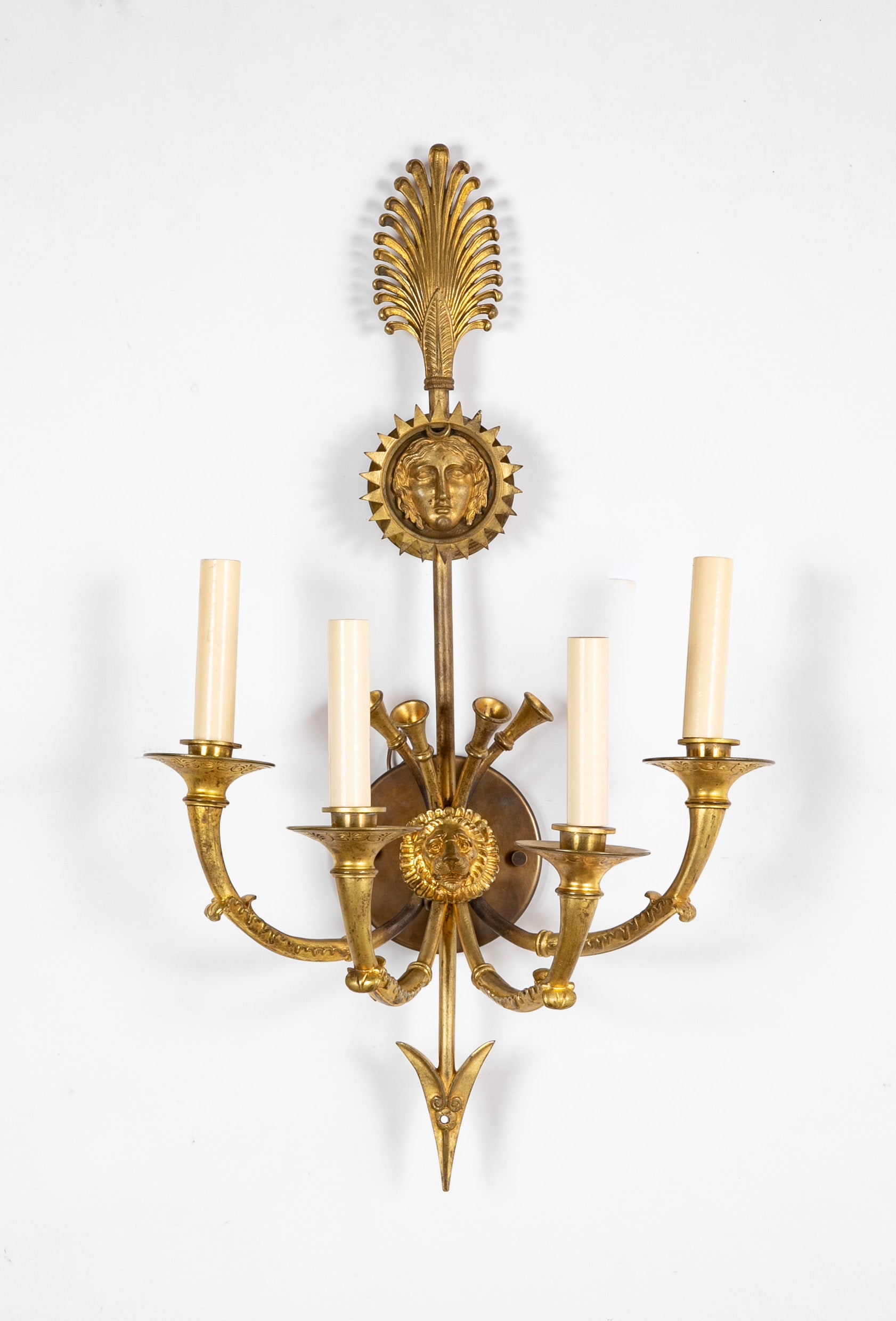 A Pair of Cast Brass Sconces in the Form of an Arrow with Face