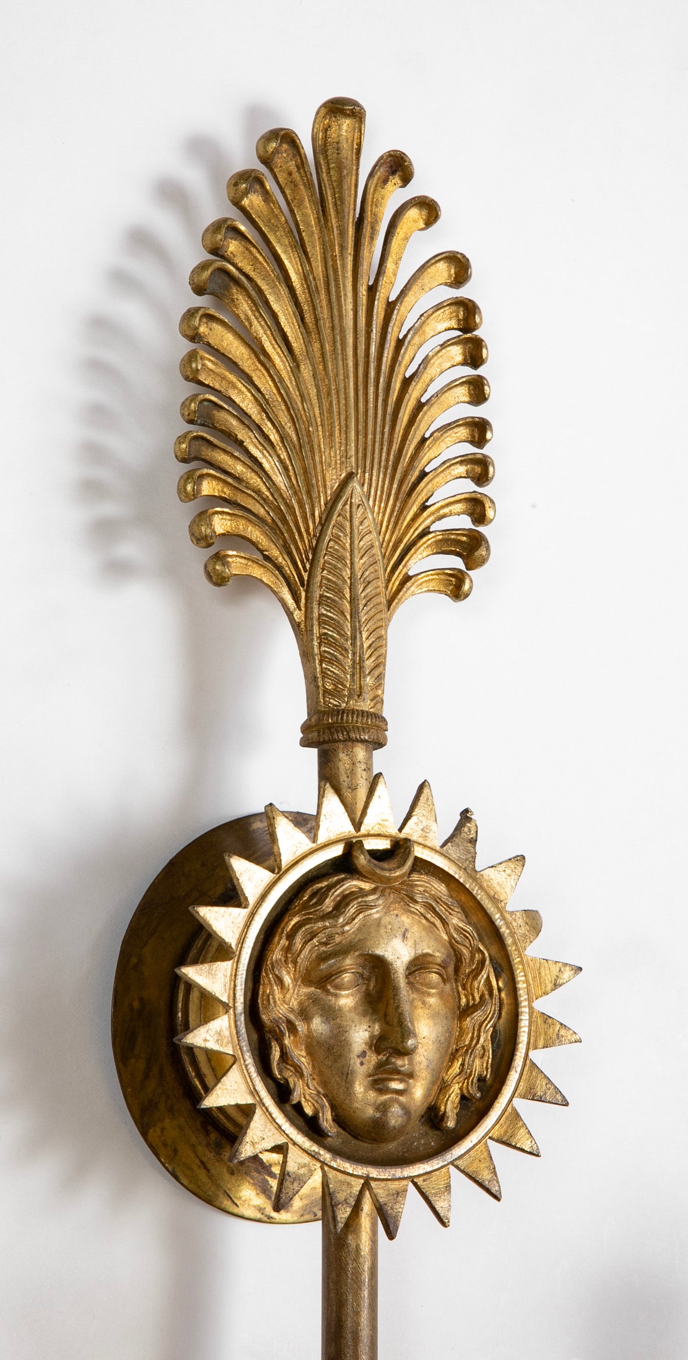 A Pair of Cast Brass Sconces in the Form of an Arrow with Face