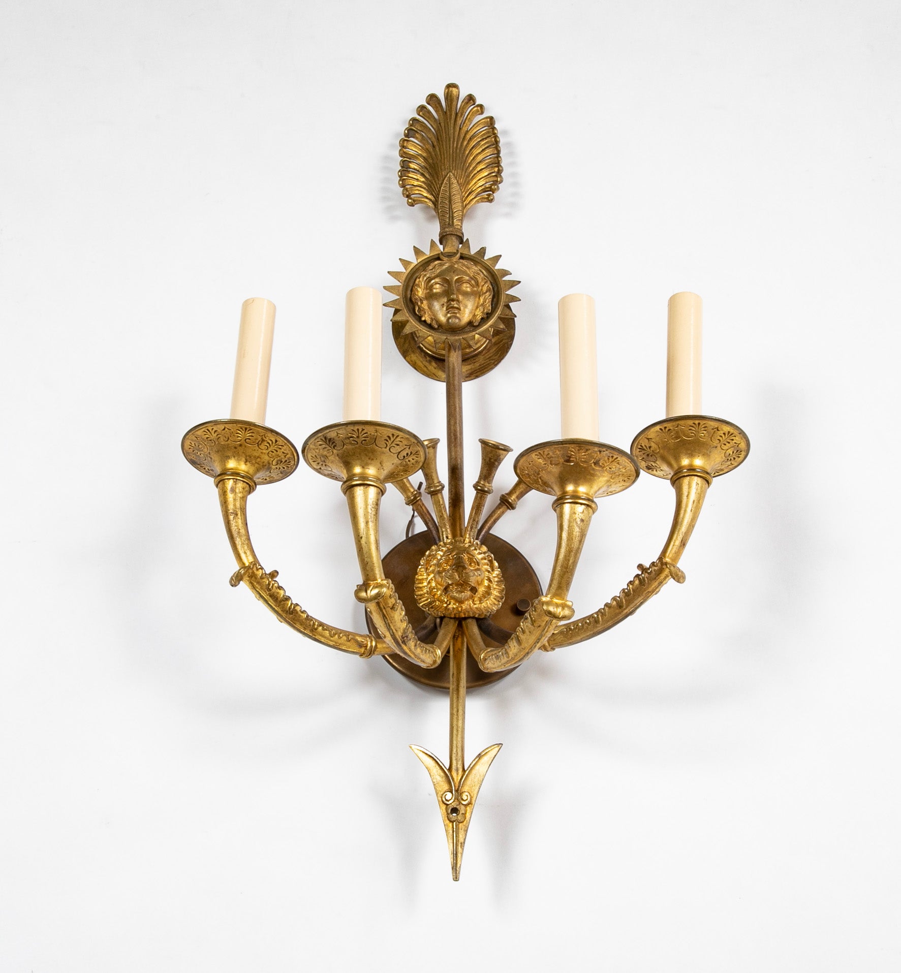A Pair of Cast Brass Sconces in the Form of an Arrow with Face
