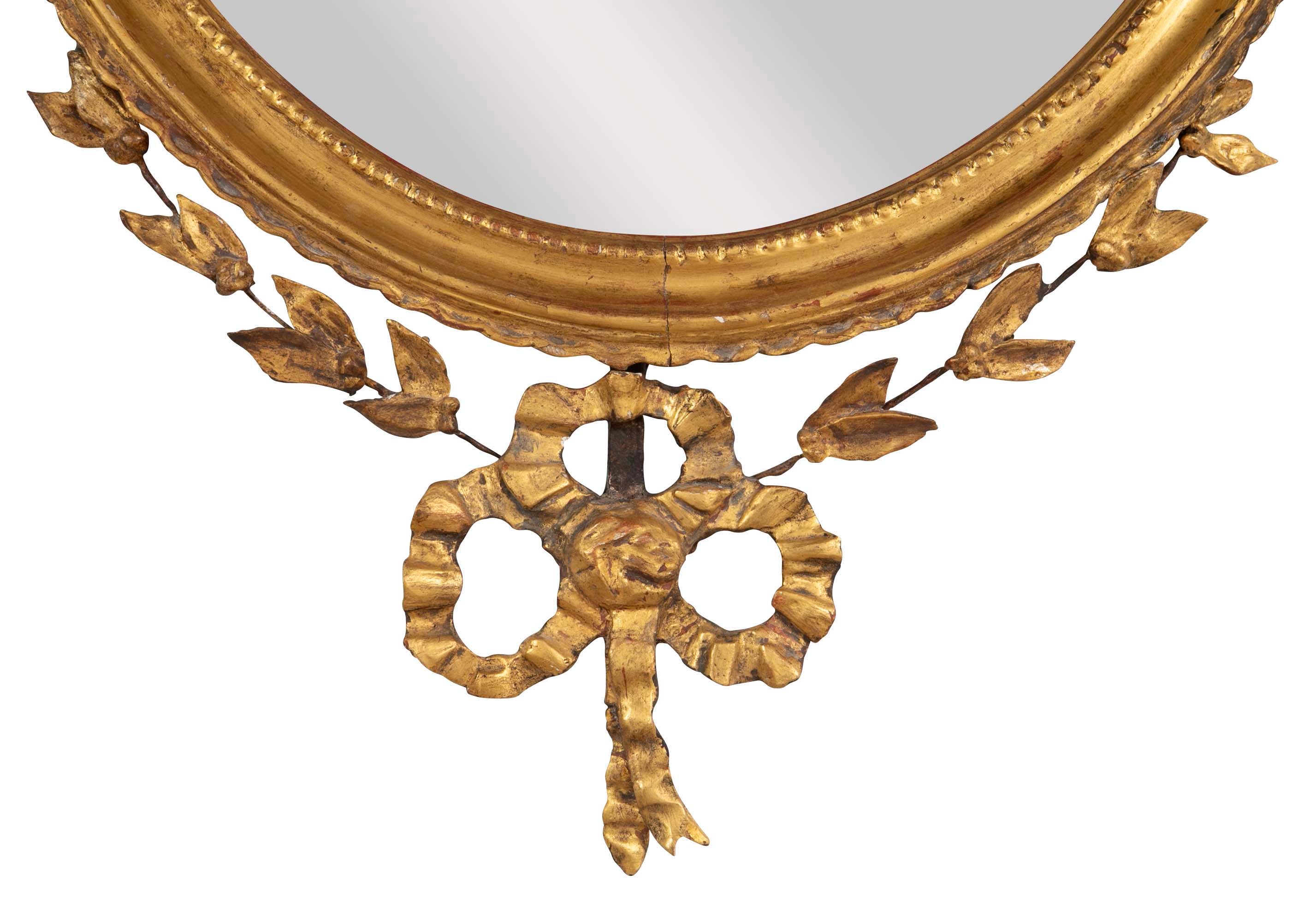 English George III Oval Hepplewhite Gilded Mirror with Ram's Head Surmount