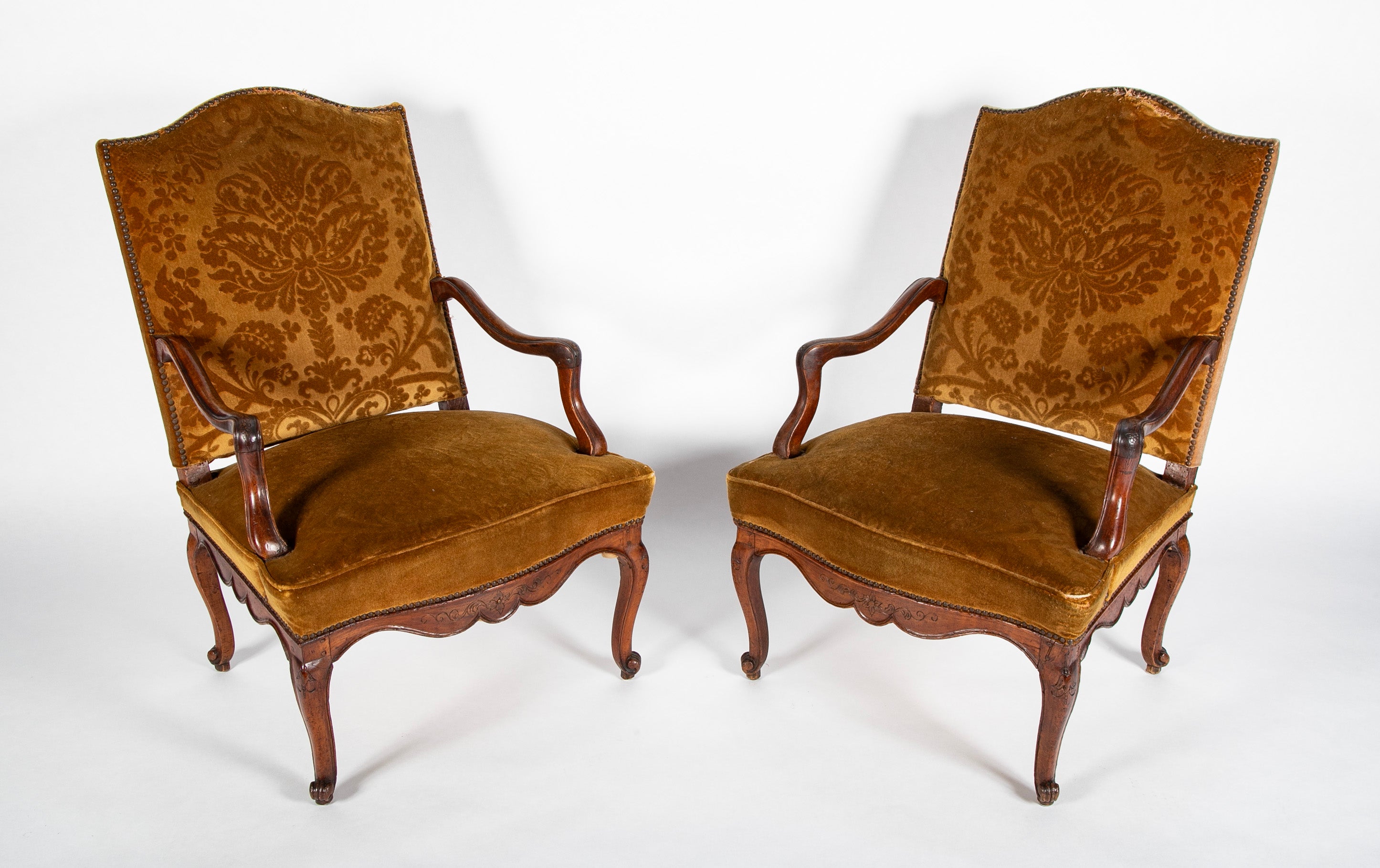 A Pair of French Carved Walnut Louis XIV Armchairs
