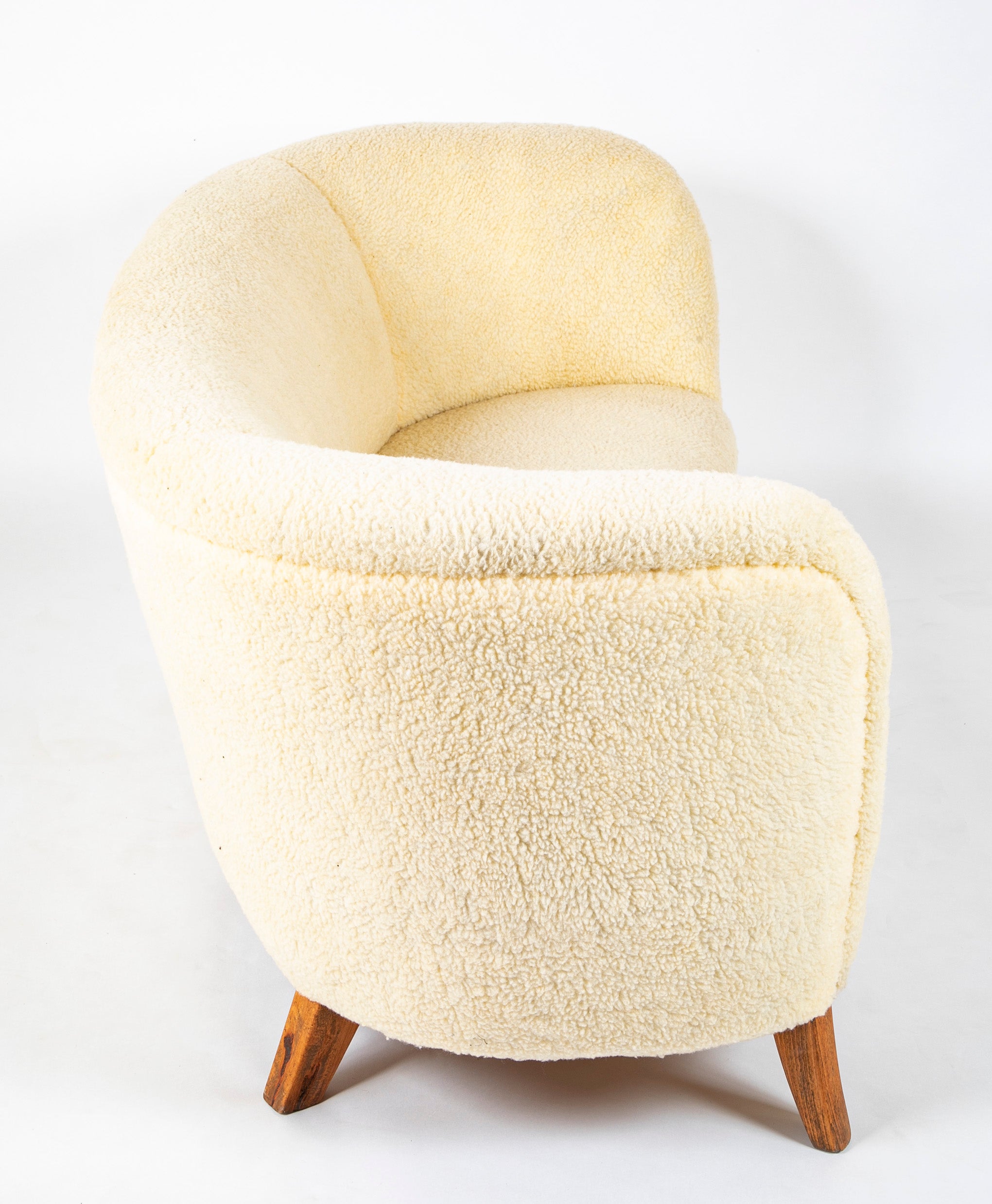 A Danish Two Seat Curved Sofa with Faux Sheepskin Upholstery