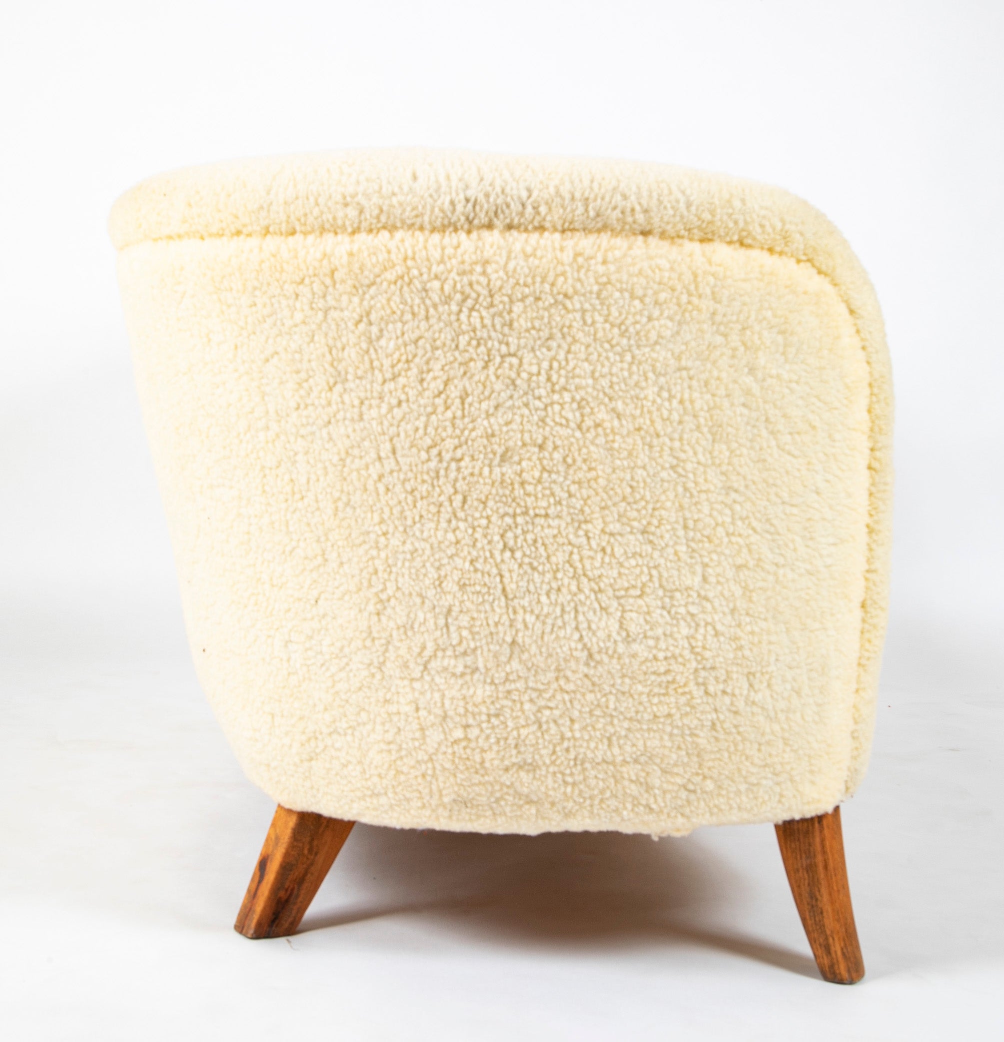 A Danish Two Seat Curved Sofa with Faux Sheepskin Upholstery