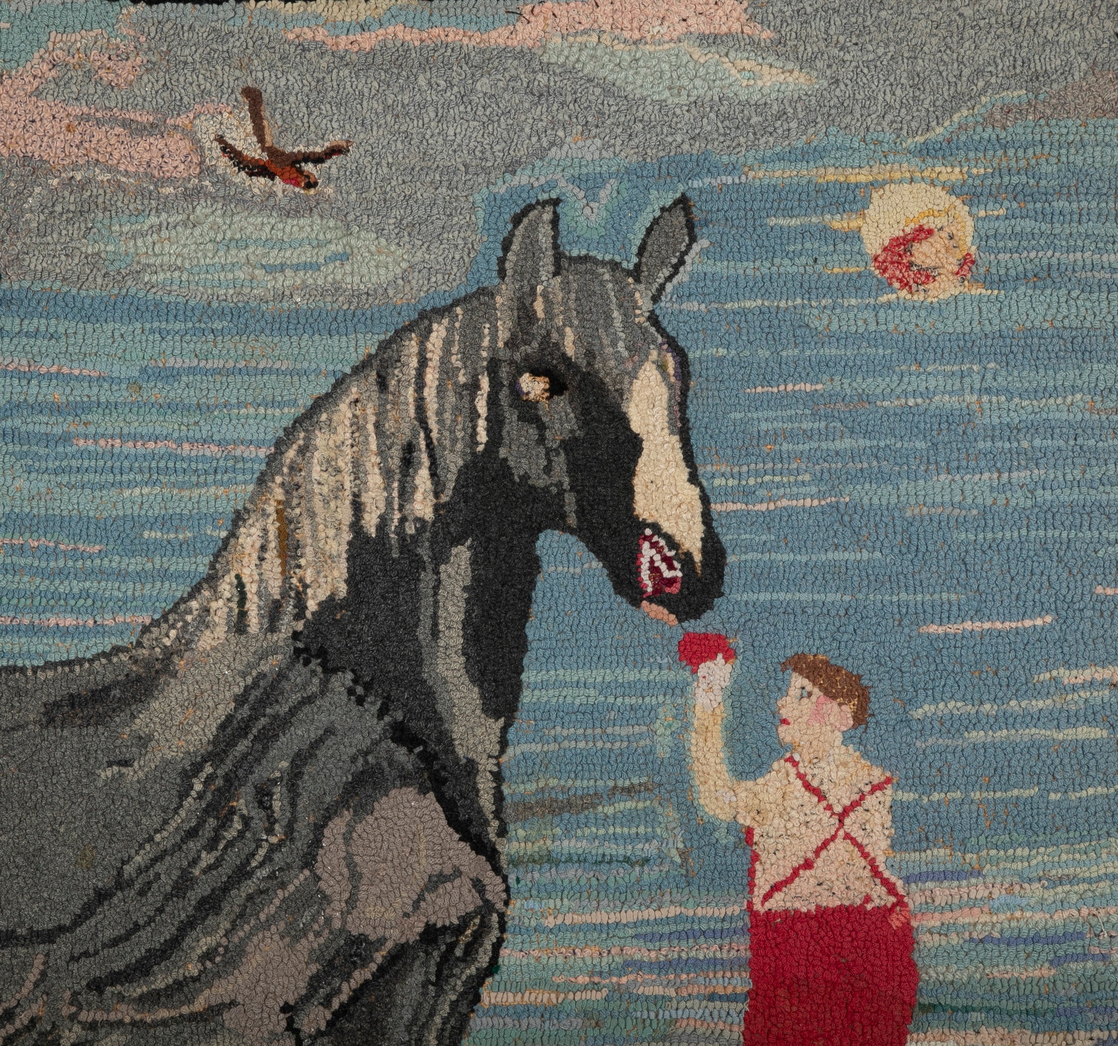An Exceptional American Hooked Rug Depicting a Boy Feeding an Apple to a Horse