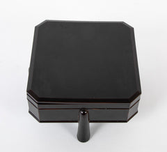 A Japanese Black Lacquer Faceted Covered Box on Four Splayed Feet