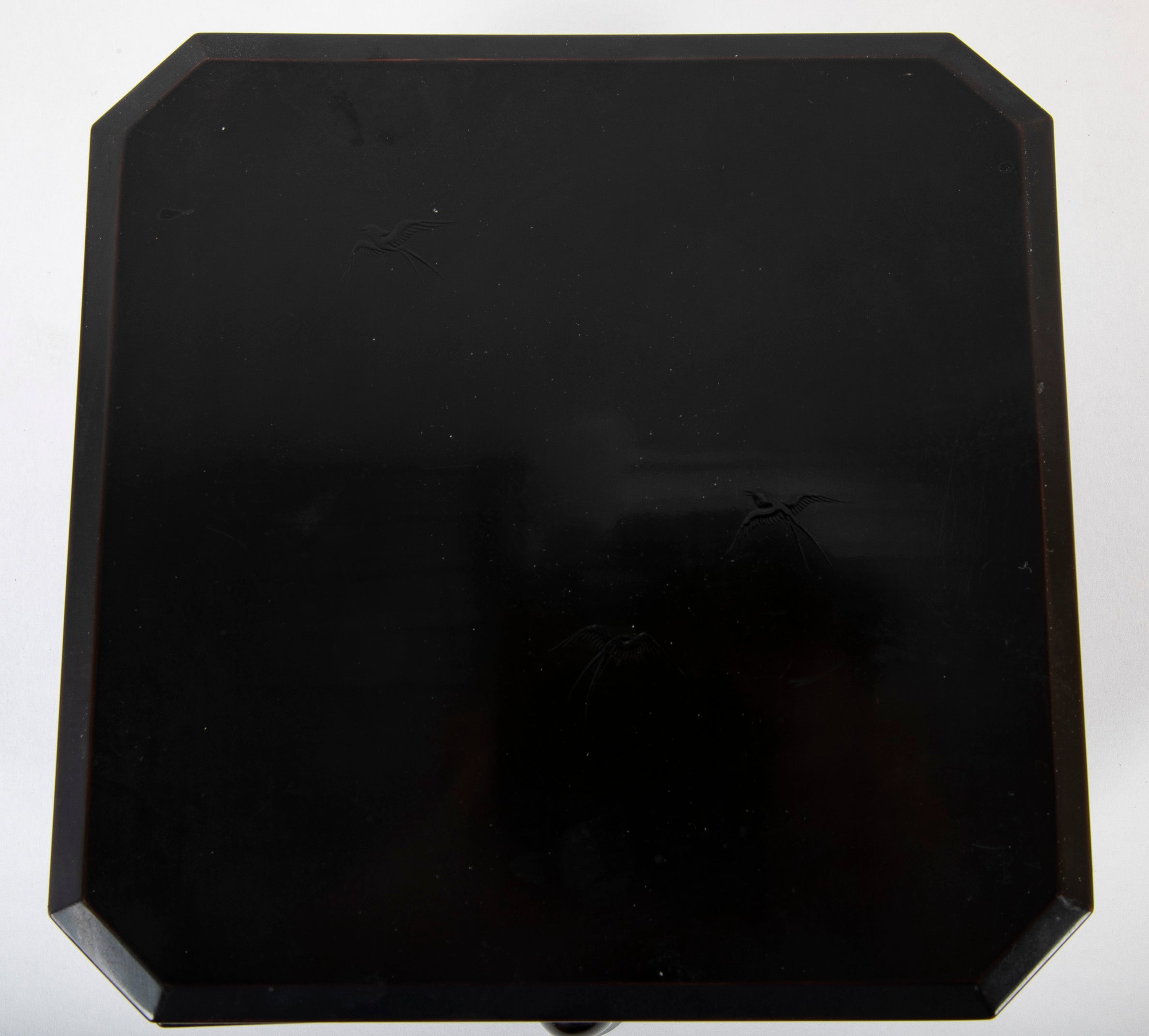 A Japanese Black Lacquer Faceted Covered Box on Four Splayed Feet