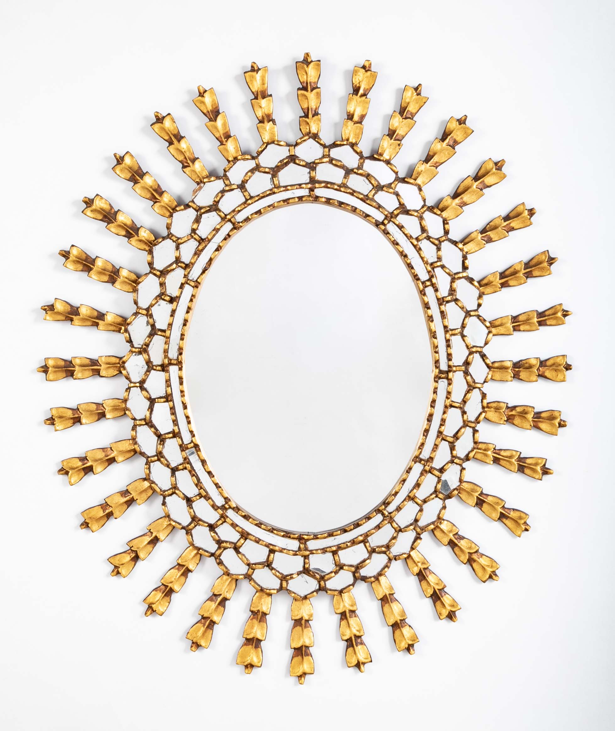 A Sunburst Oval Mirror with Leaf Forms on Rays