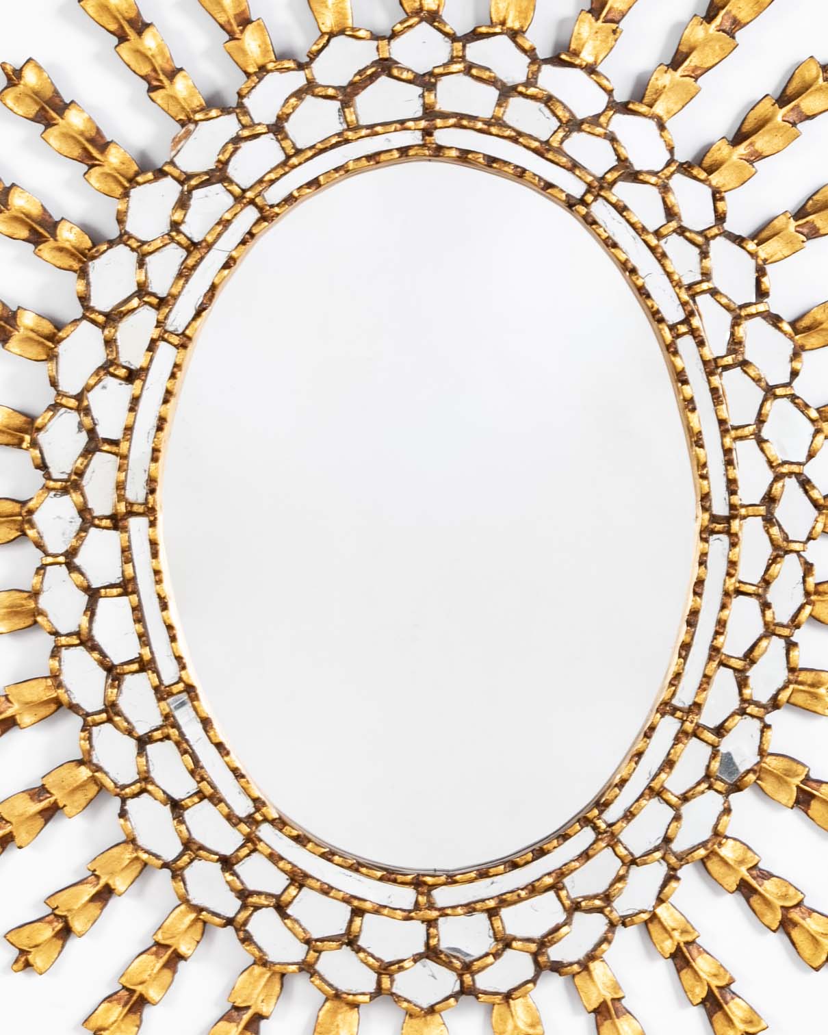 A Sunburst Oval Mirror with Leaf Forms on Rays