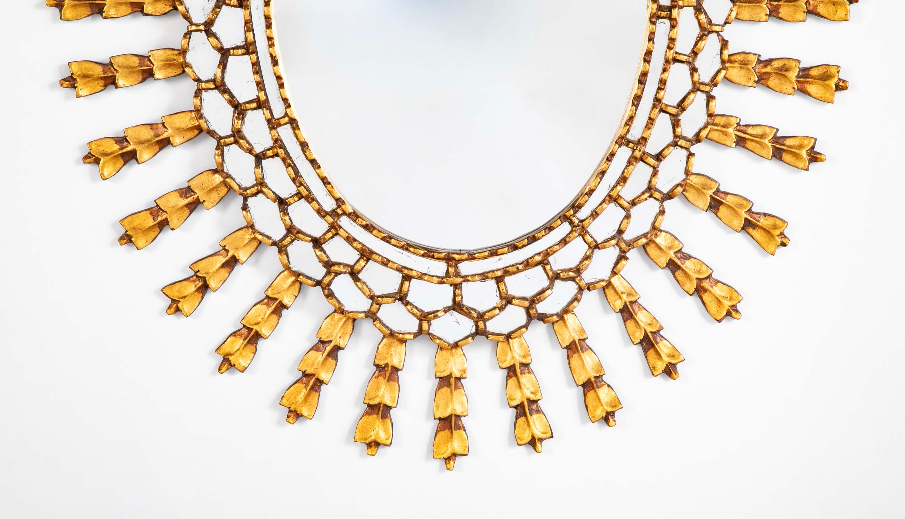 A Sunburst Oval Mirror with Leaf Forms on Rays