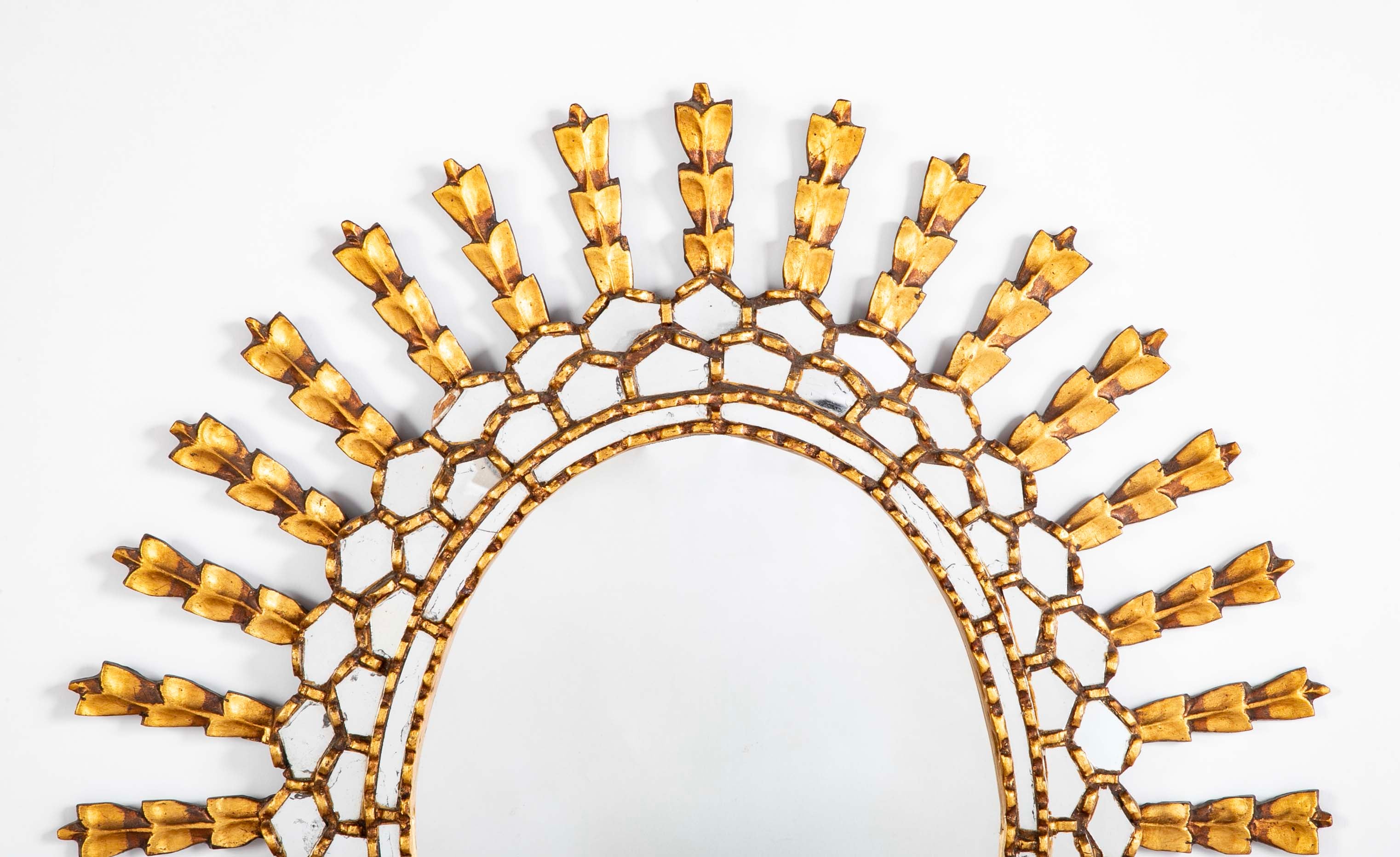 A Sunburst Oval Mirror with Leaf Forms on Rays