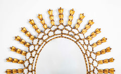 A Sunburst Oval Mirror with Leaf Forms on Rays