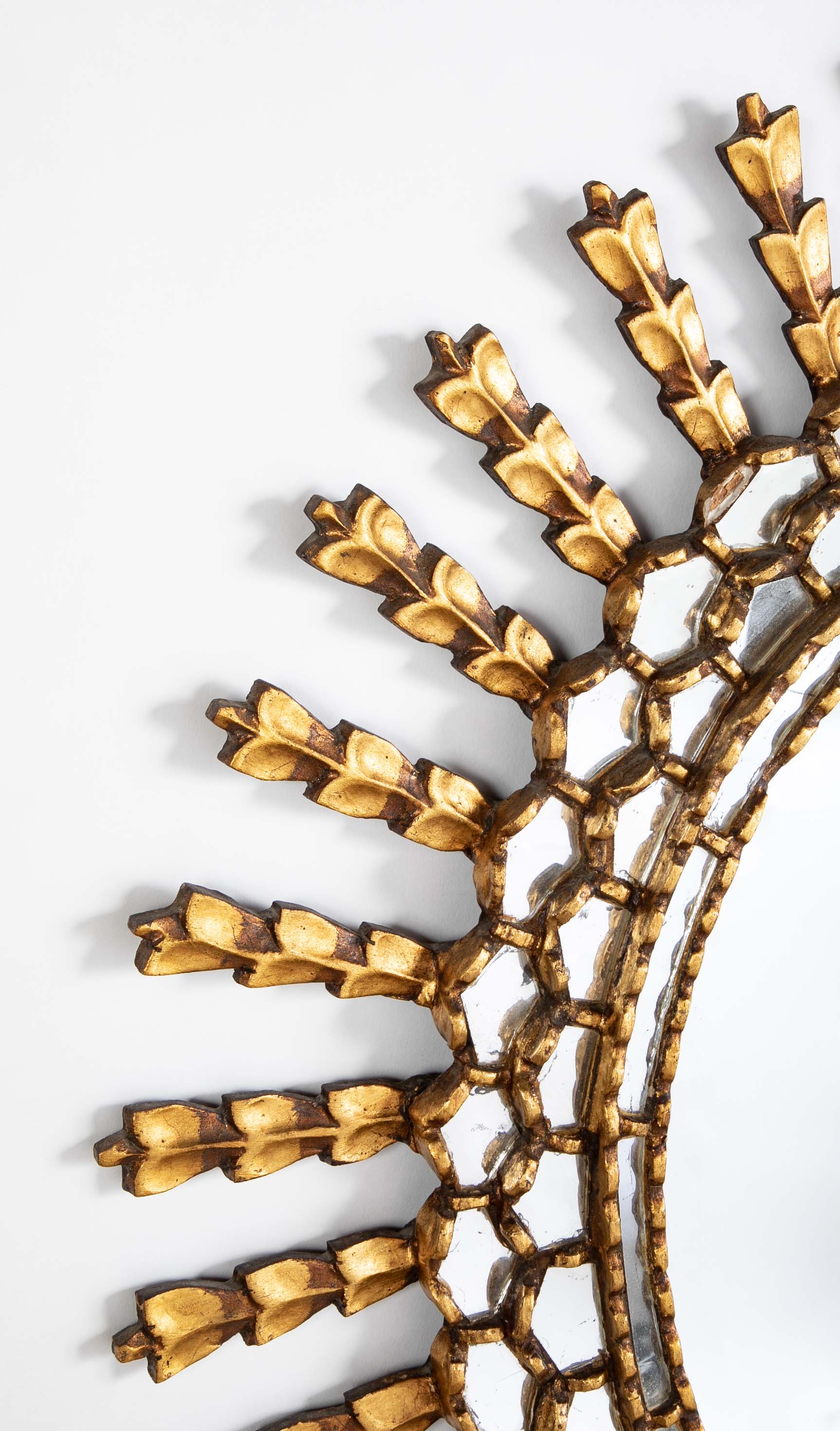 A Sunburst Oval Mirror with Leaf Forms on Rays