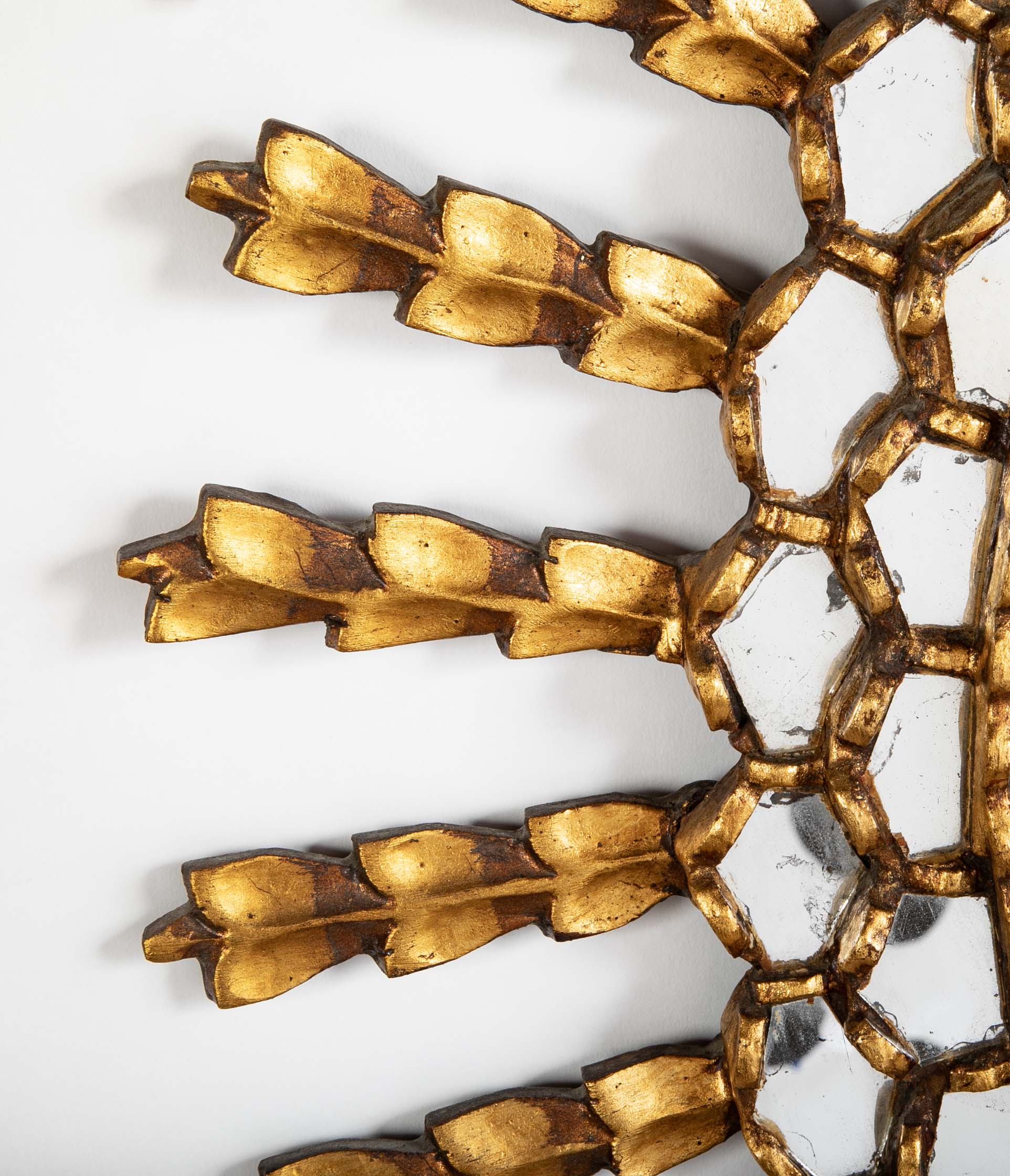 A Sunburst Oval Mirror with Leaf Forms on Rays