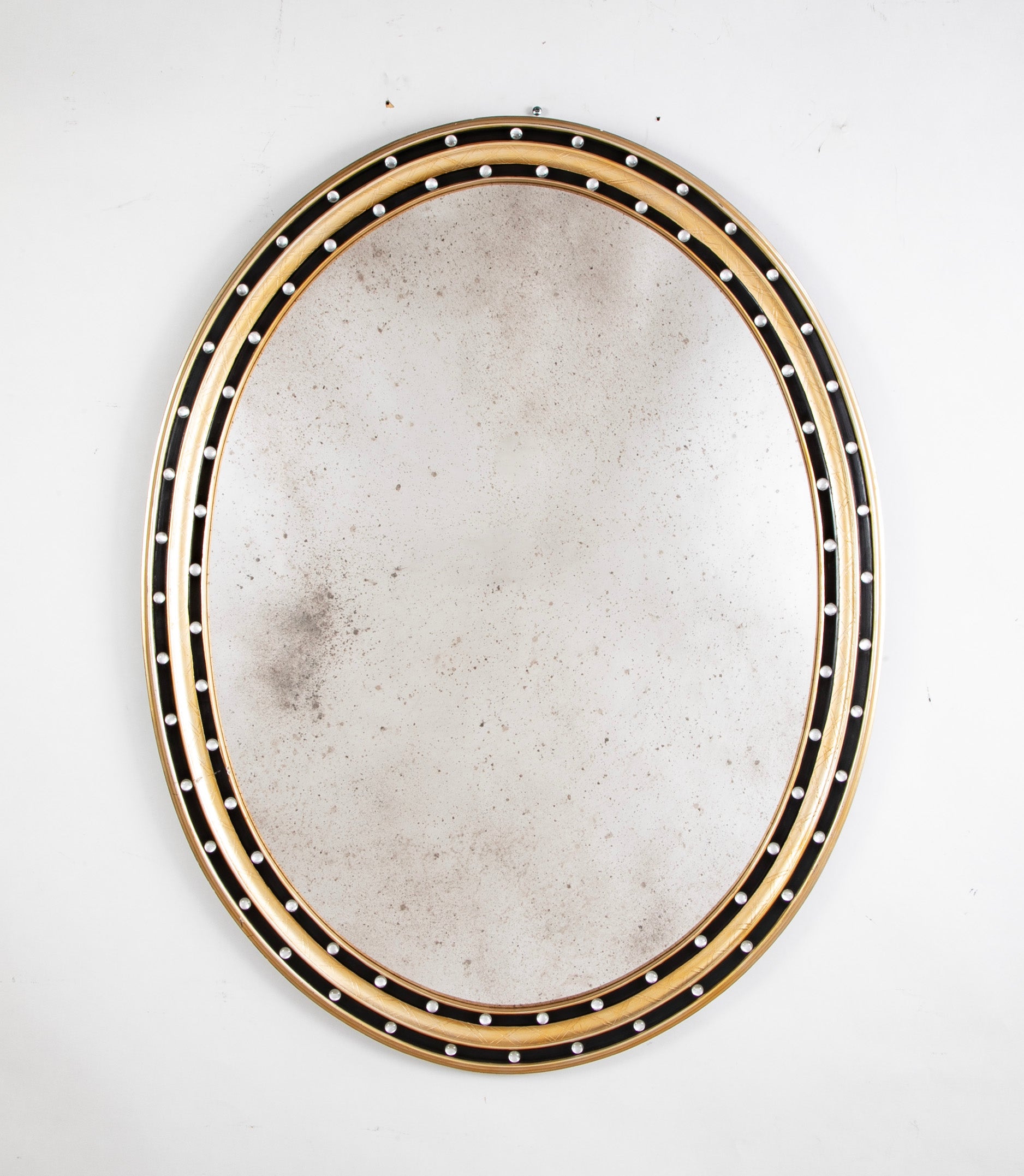An Irish Ebonized & Parcel Gilt Oval Mirror with Faceted Bead Decoration