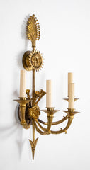 A Pair of Cast Brass Sconces in the Form of an Arrow with Face