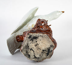 A Japanese White Glazed Porcelain Hawk Perched on a Tree Stump