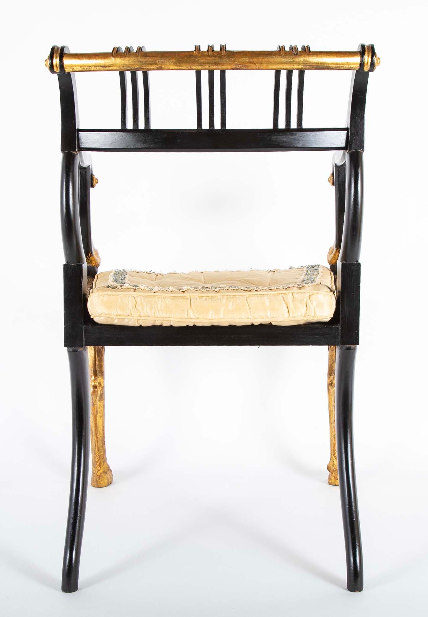 A Pair of Regency Style Ebonized and Parcel Gilt Armchairs