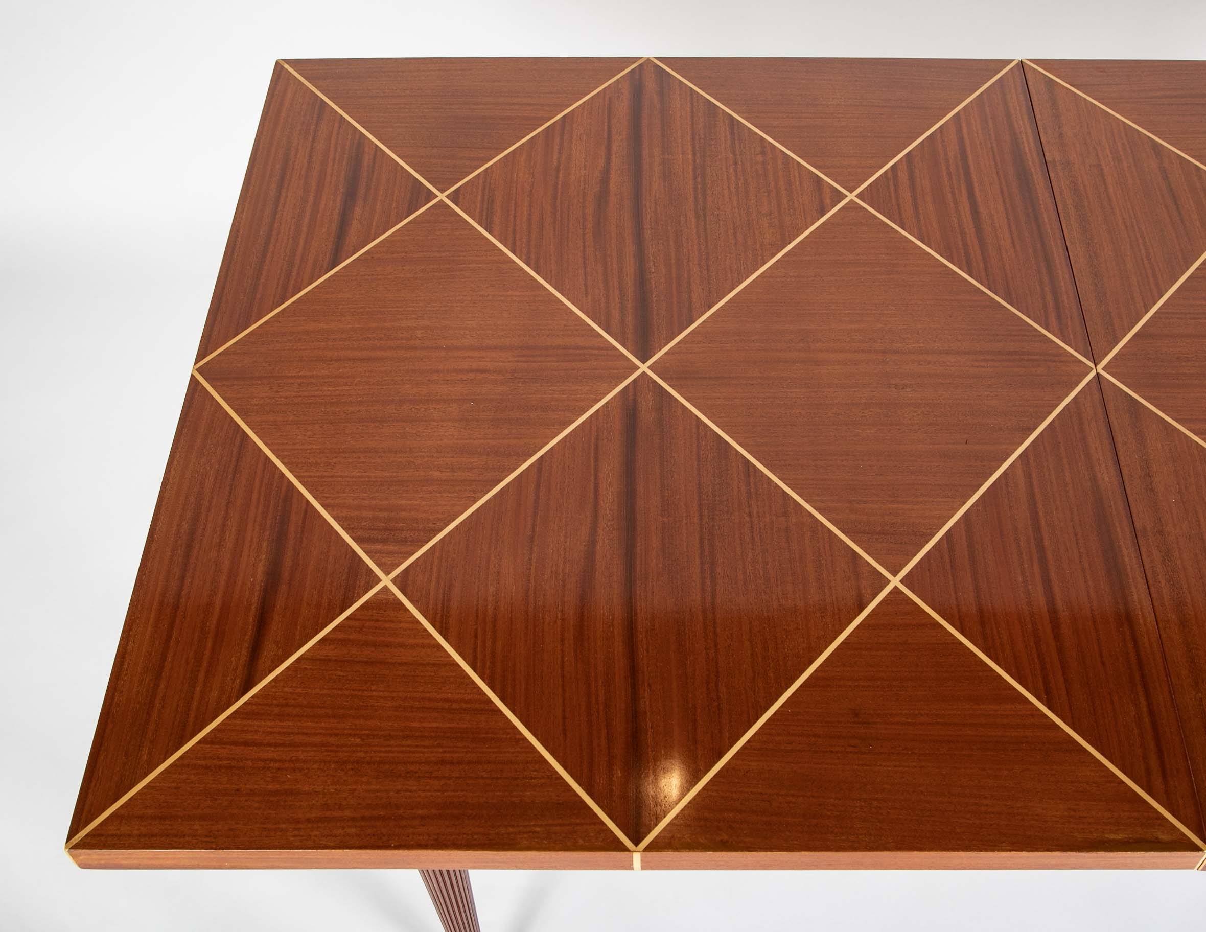 A Tommi Parzinger for Charak Modern Mahogany and Maple Dining Table with Leaves.