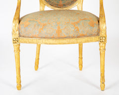 A Pair of George III Period Giltwood Oval Back "Elbow" Chairs