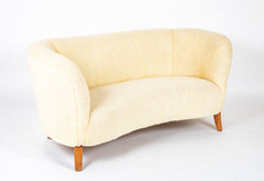 A Danish Two Seat Curved Sofa with Faux Sheepskin Upholstery