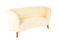 A Danish Two Seat Curved Sofa with Faux Sheepskin Upholstery