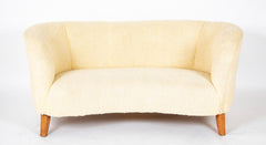 A Danish Two Seat Curved Sofa with Faux Sheepskin Upholstery