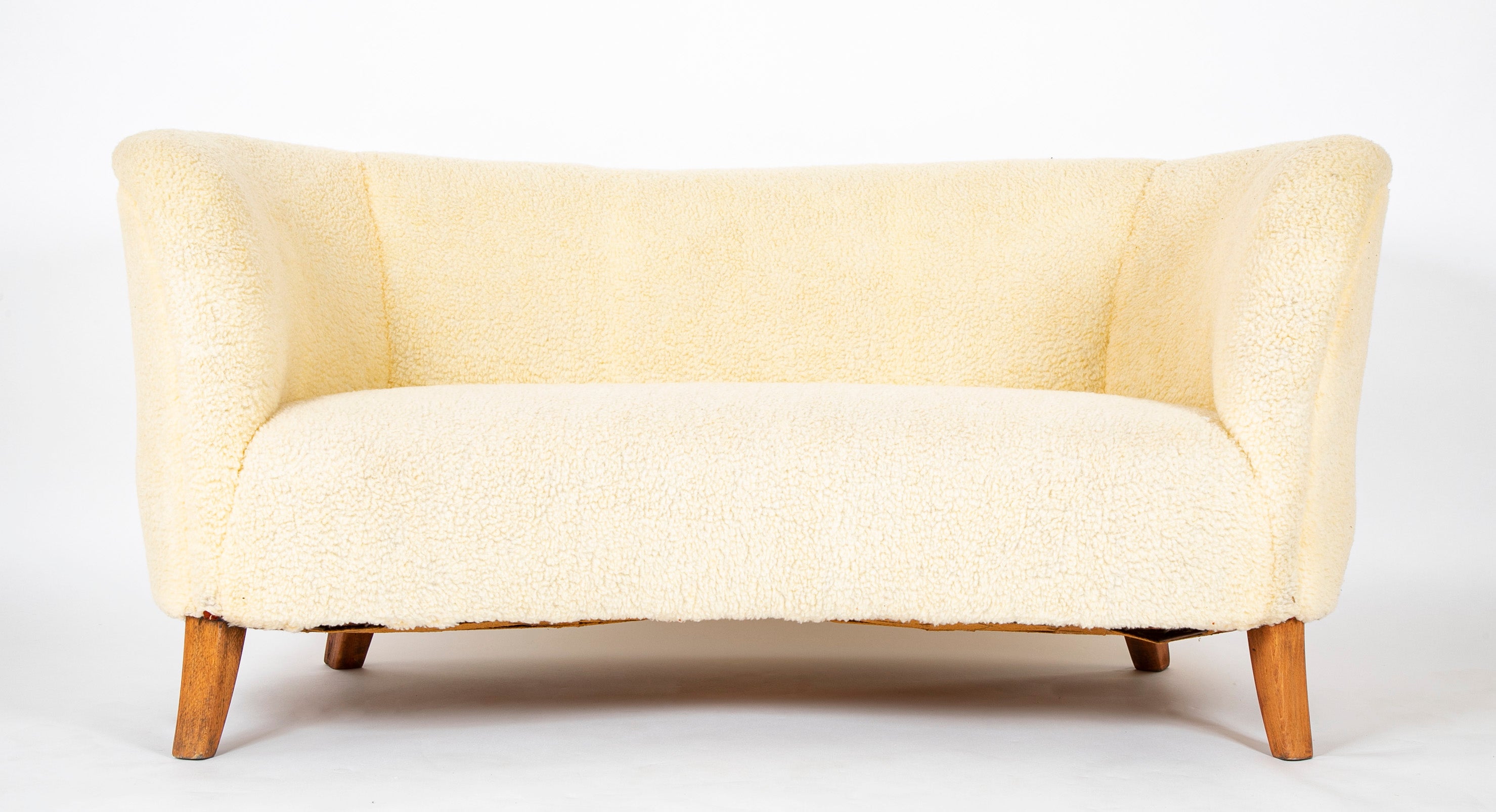 A Danish Two Seat Curved Sofa with Faux Sheepskin Upholstery