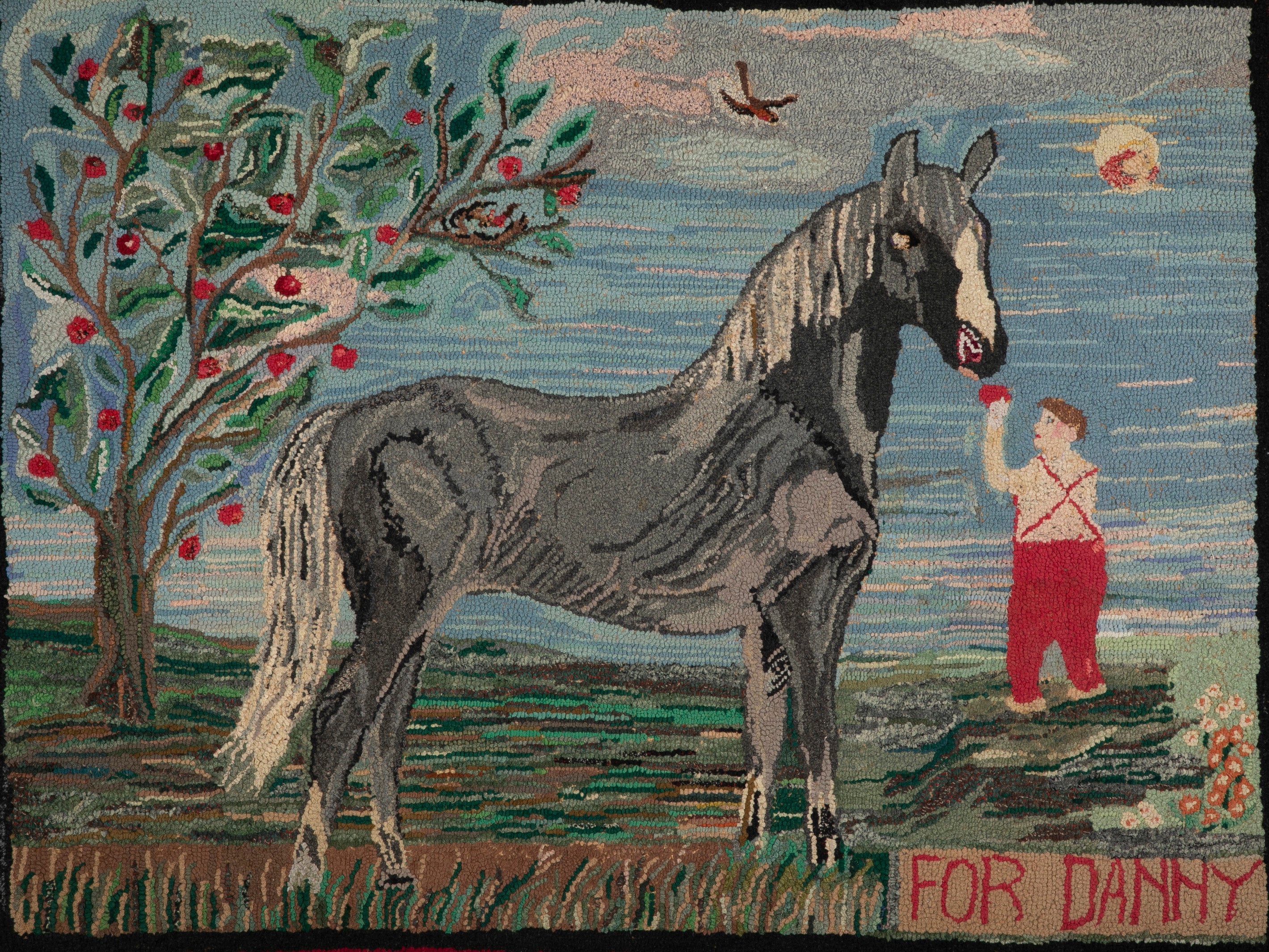 An Exceptional American Hooked Rug Depicting a Boy Feeding an Apple to a Horse