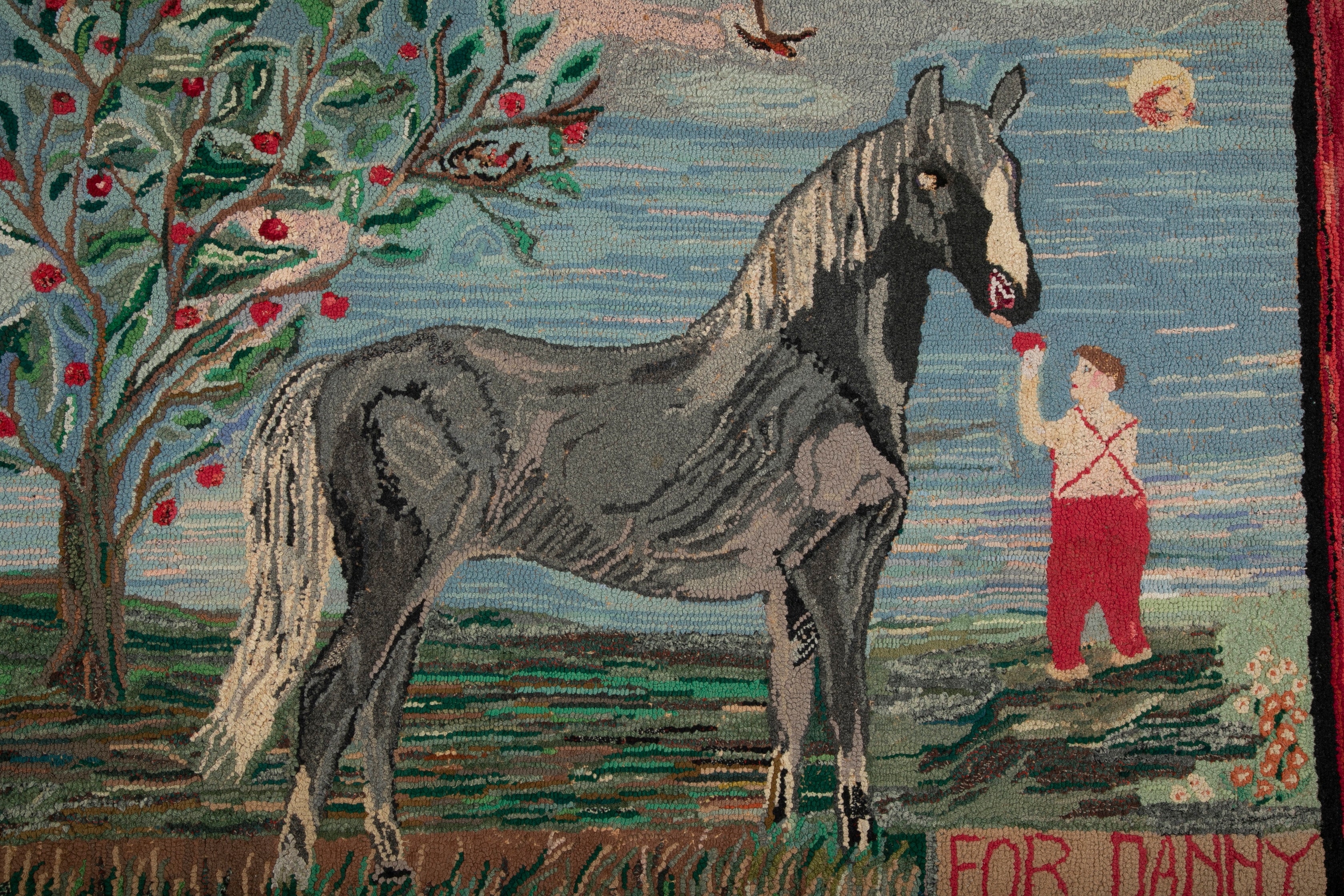 An Exceptional American Hooked Rug Depicting a Boy Feeding an Apple to a Horse