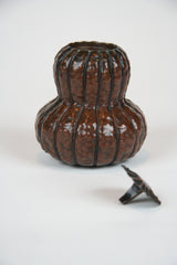 A Japanese Repousse Copper Scroll Weight in the Form of a Gourd